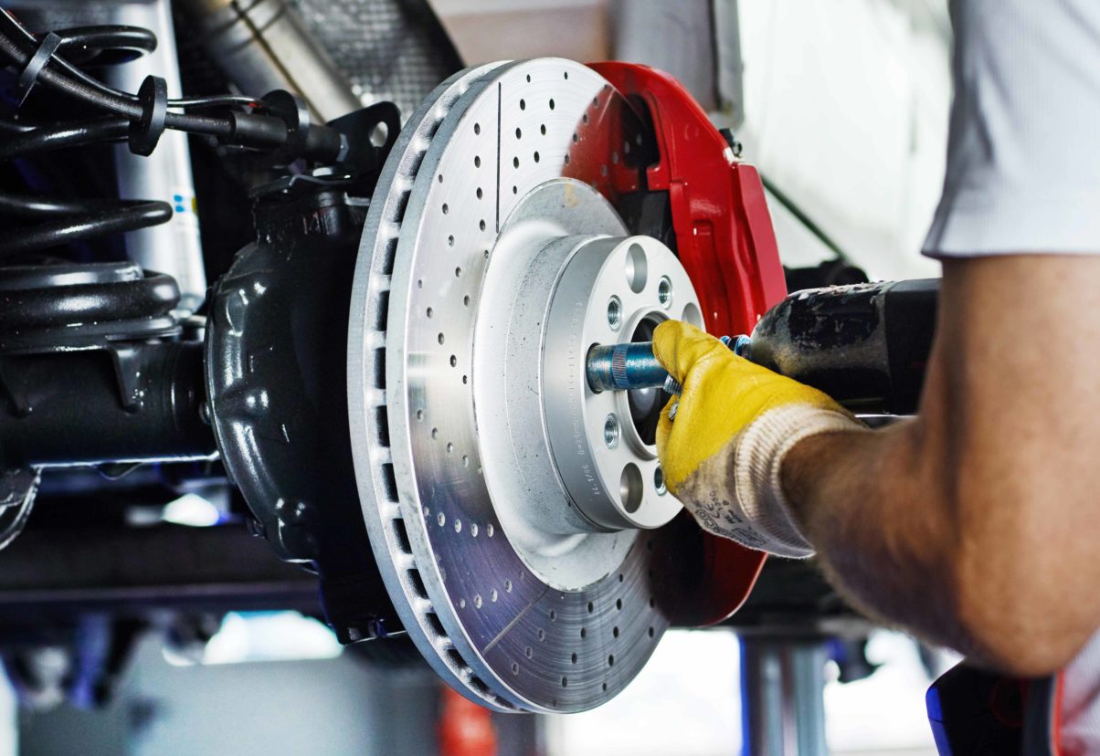 brake service technician repairing car brakes at pampered auto care in austin, texas near round rock and cedar park